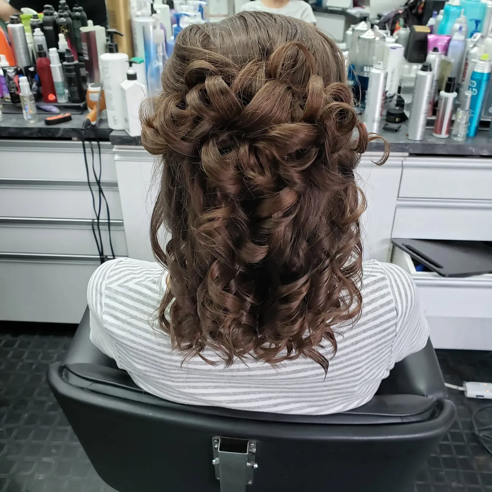 Boucles serrées sur un demi-attaché tressé — photo prise au Salon de la Coupe